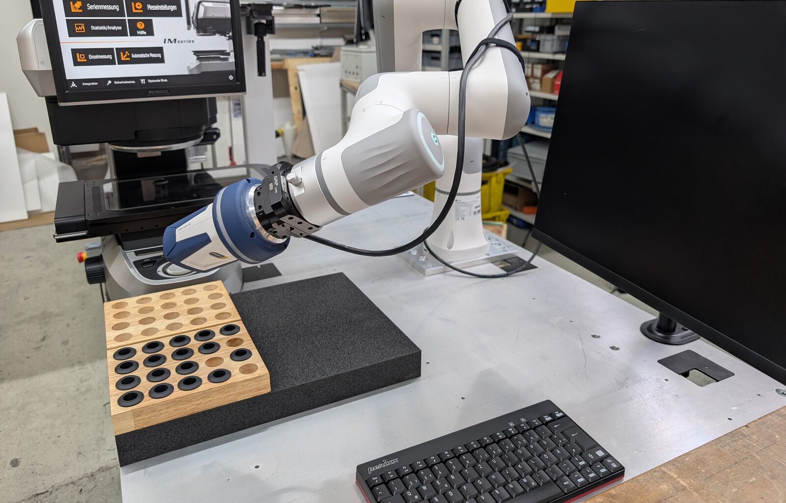 Cobot belädt eine Keyence-IM-Messmaschine mit Teilen aus dem Teileträger – automatisierte Serienmessung
